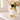 Bottle of oil labeled 'Soul' on a marble surface with flowers in the background