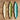 Three leaf-shaped ceramic plates in beige, green, and blue on a wooden surface